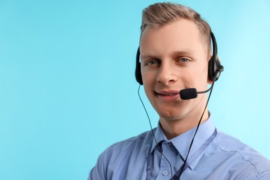 Photo of Technical support call center. Smiling operator on light blue background. Space for text