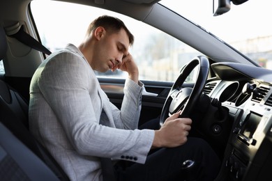 Photo of Tired driver sleeping in his modern car