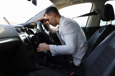 Tired driver sleeping on steering wheel in car