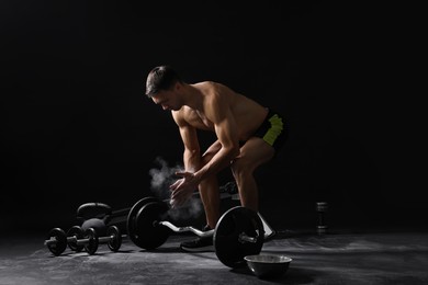 Photo of Man clapping hands with talcum powder before training on black background