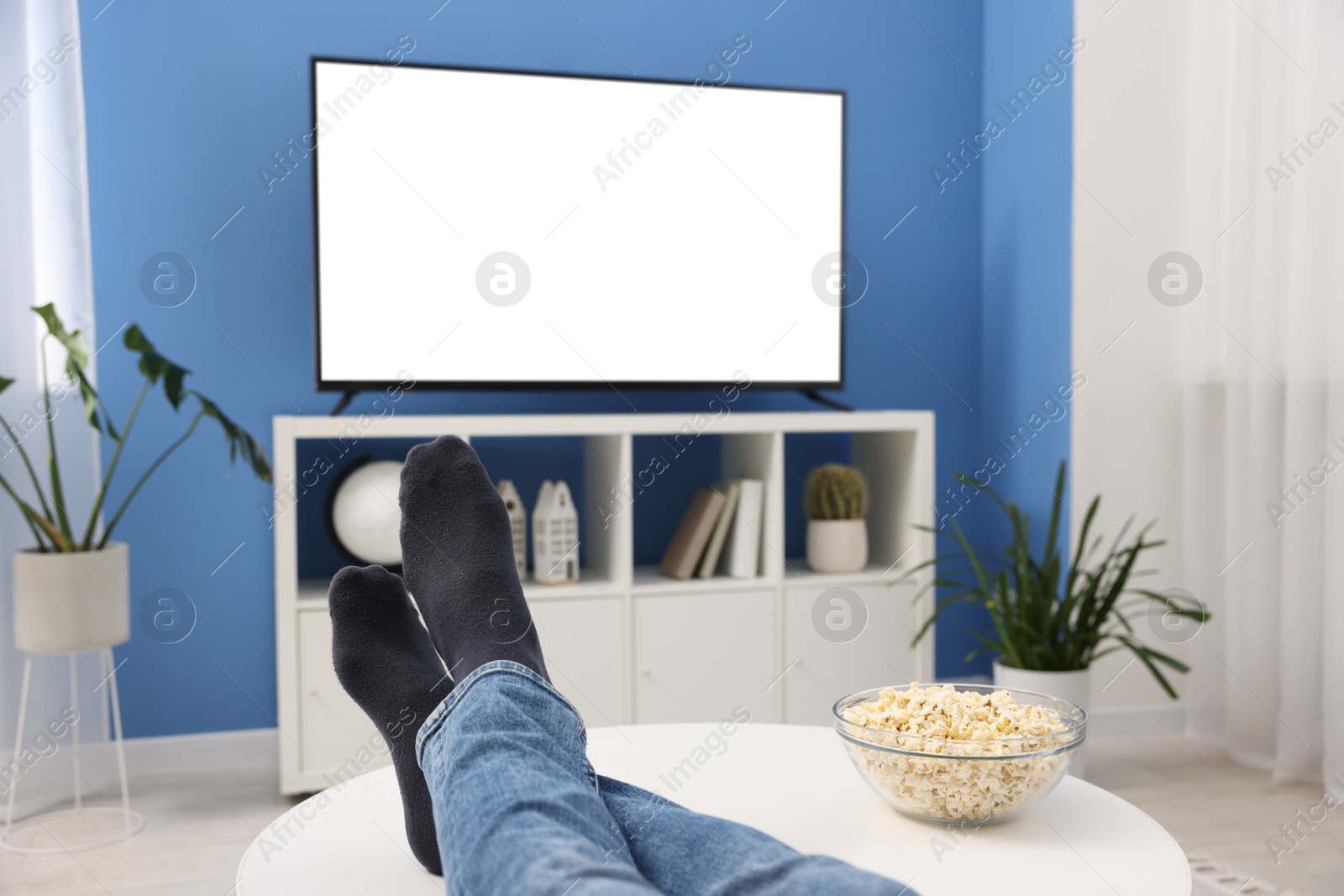 Photo of Man with popcorn watching tv at home, closeup