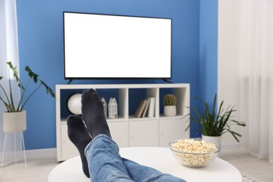 Photo of Man with popcorn watching tv at home, closeup