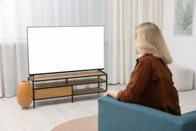 Photo of Woman watching tv on couch at home