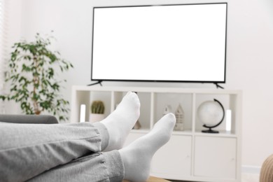 Photo of Woman watching tv on couch at home, closeup