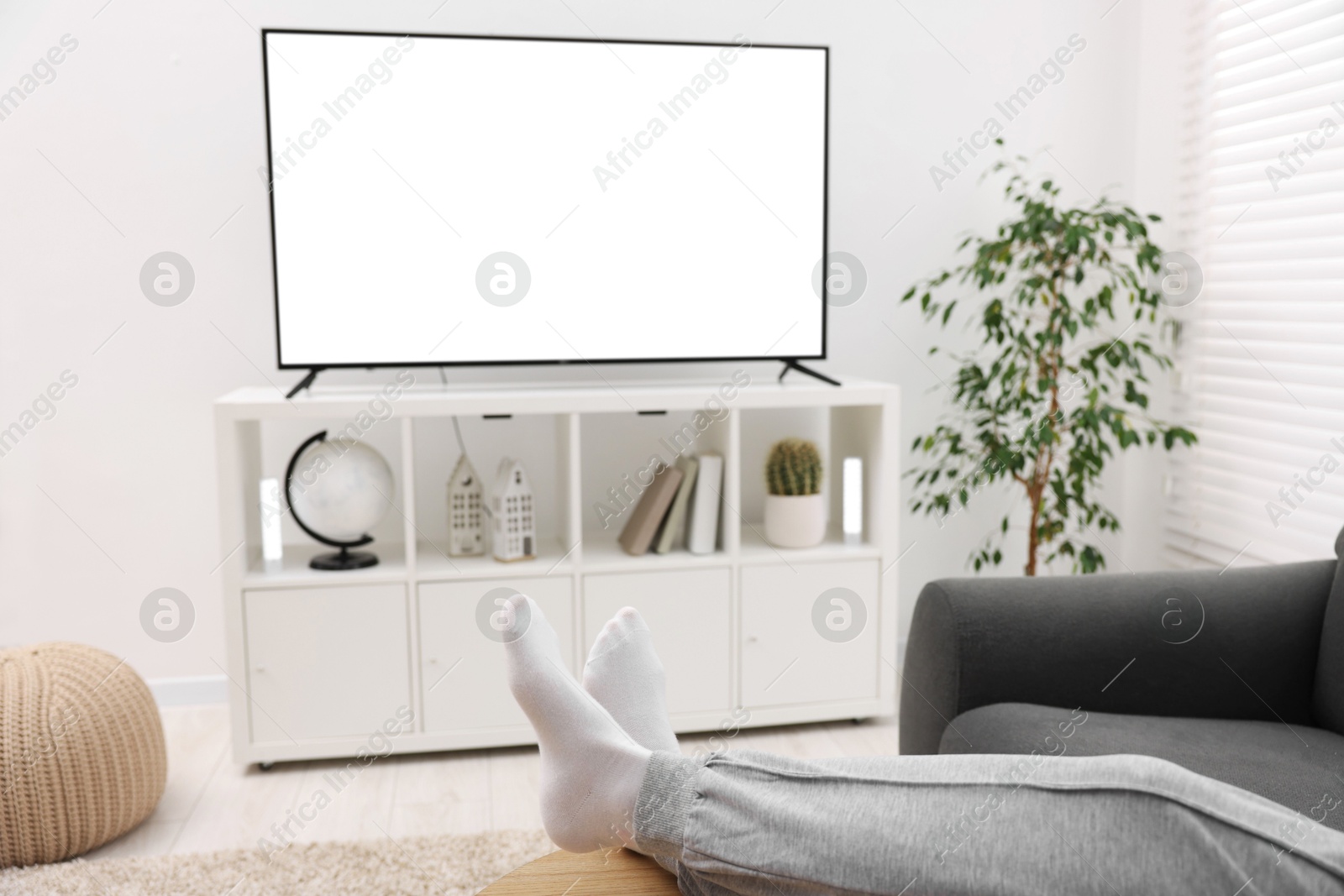 Photo of Woman watching tv on couch at home, closeup