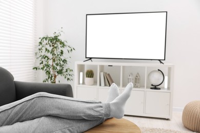 Photo of Woman watching tv on couch at home, closeup