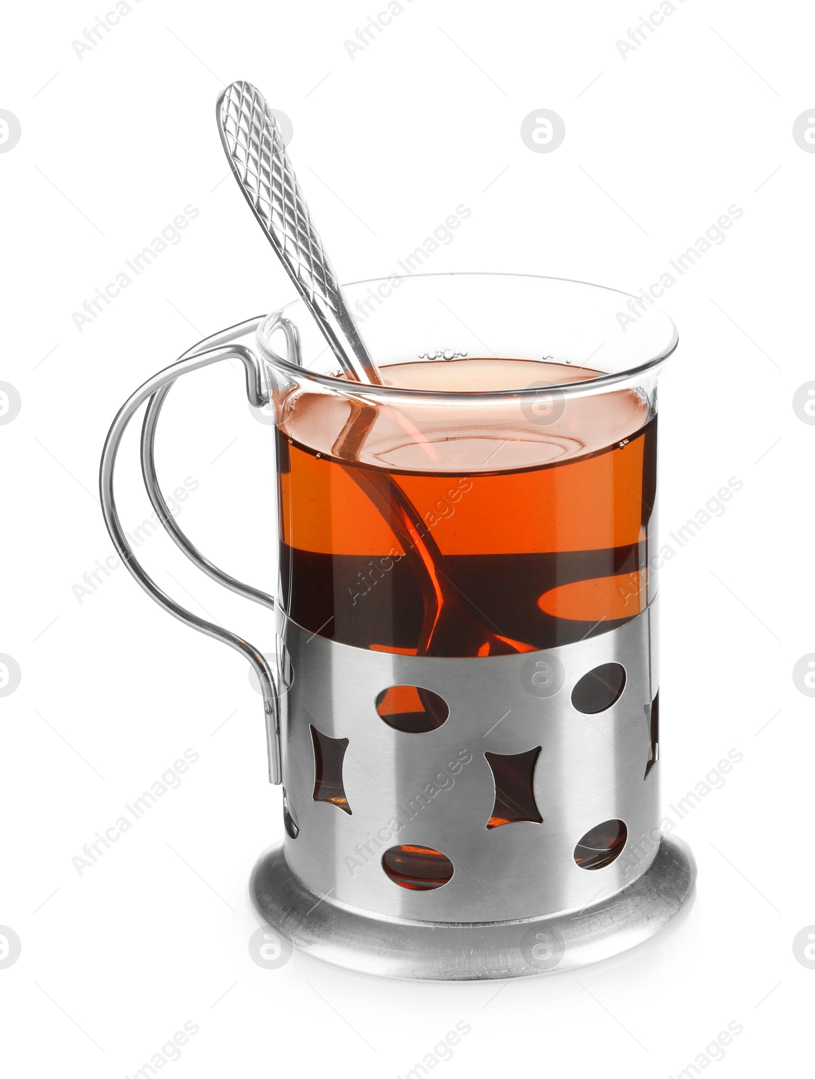 Photo of Glass of aromatic tea in holder and spoon isolated on white