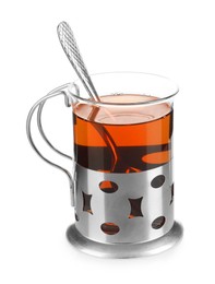 Photo of Glass of aromatic tea in holder and spoon isolated on white