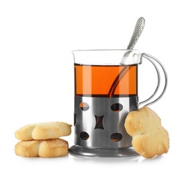 Photo of Glass of aromatic tea in holder, spoon and cookies isolated on white