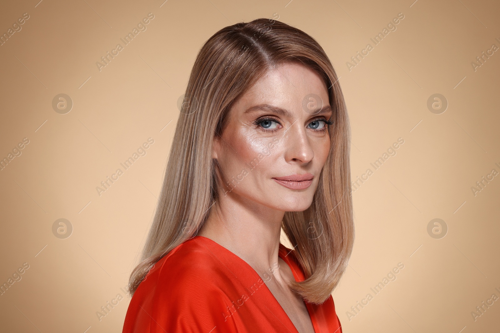 Photo of Beautiful woman with straight blonde hair on beige background