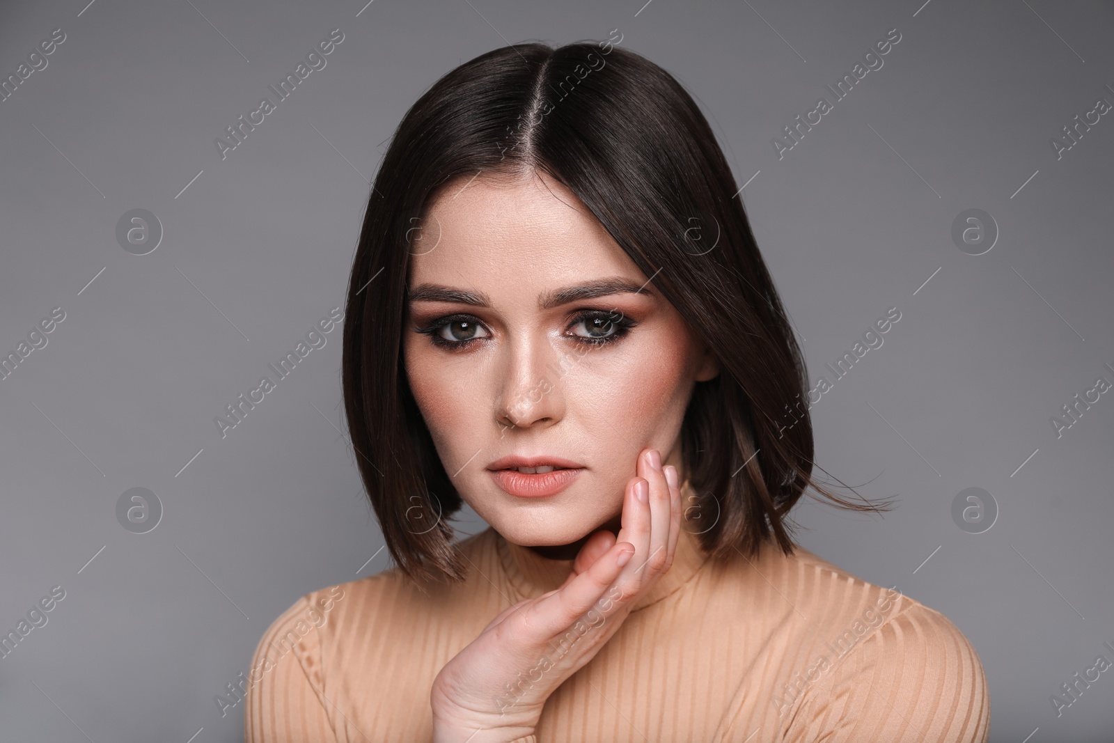 Photo of Portrait of beautiful young woman with gorgeous straight hair on grey background