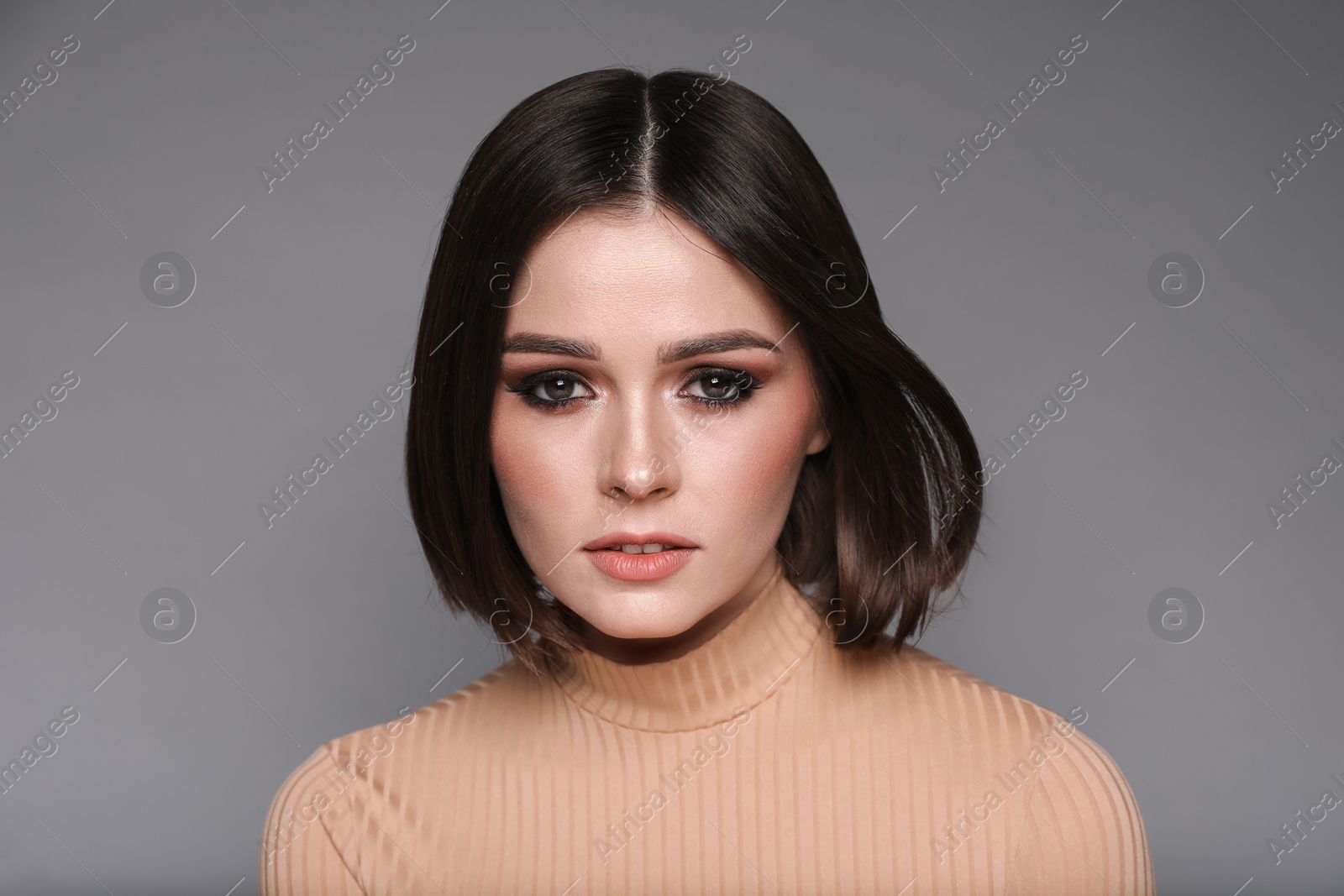 Photo of Portrait of beautiful young woman with gorgeous straight hair on grey background