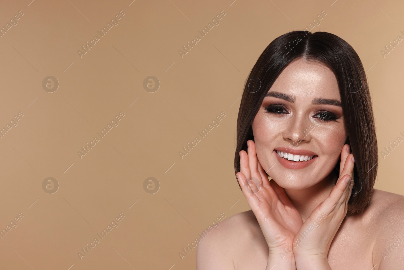 Photo of Portrait of beautiful young happy woman with gorgeous straight hair on beige background, space for text