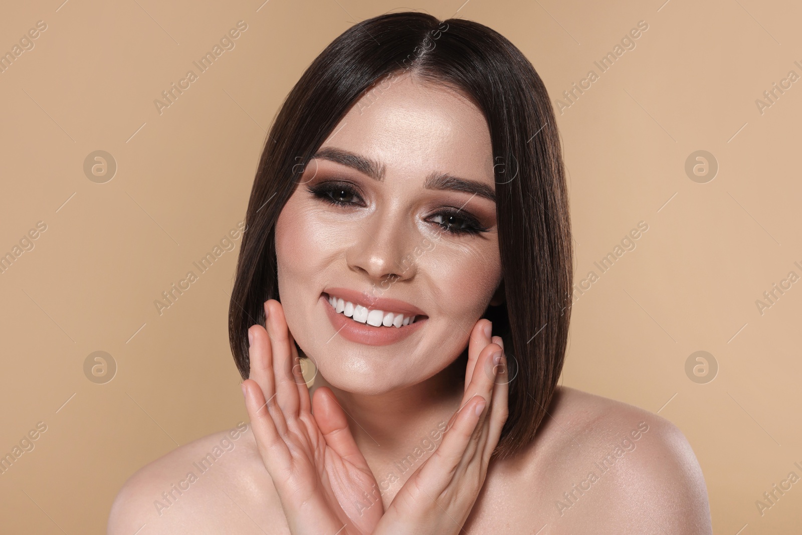 Photo of Portrait of beautiful young happy woman with gorgeous straight hair on beige background