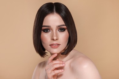 Photo of Portrait of beautiful young woman with gorgeous straight hair on beige background