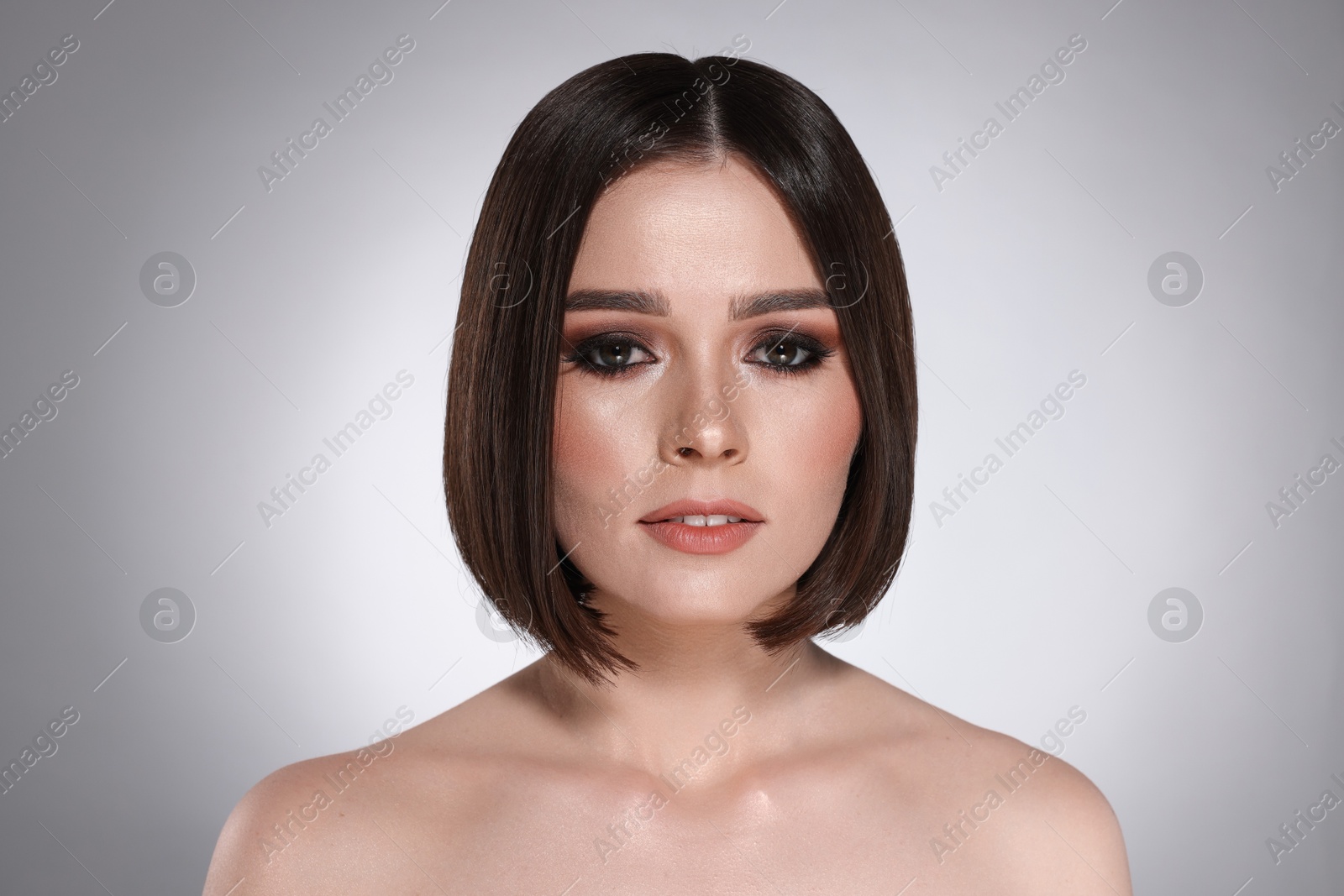 Photo of Portrait of beautiful young woman with gorgeous straight hair on light grey background