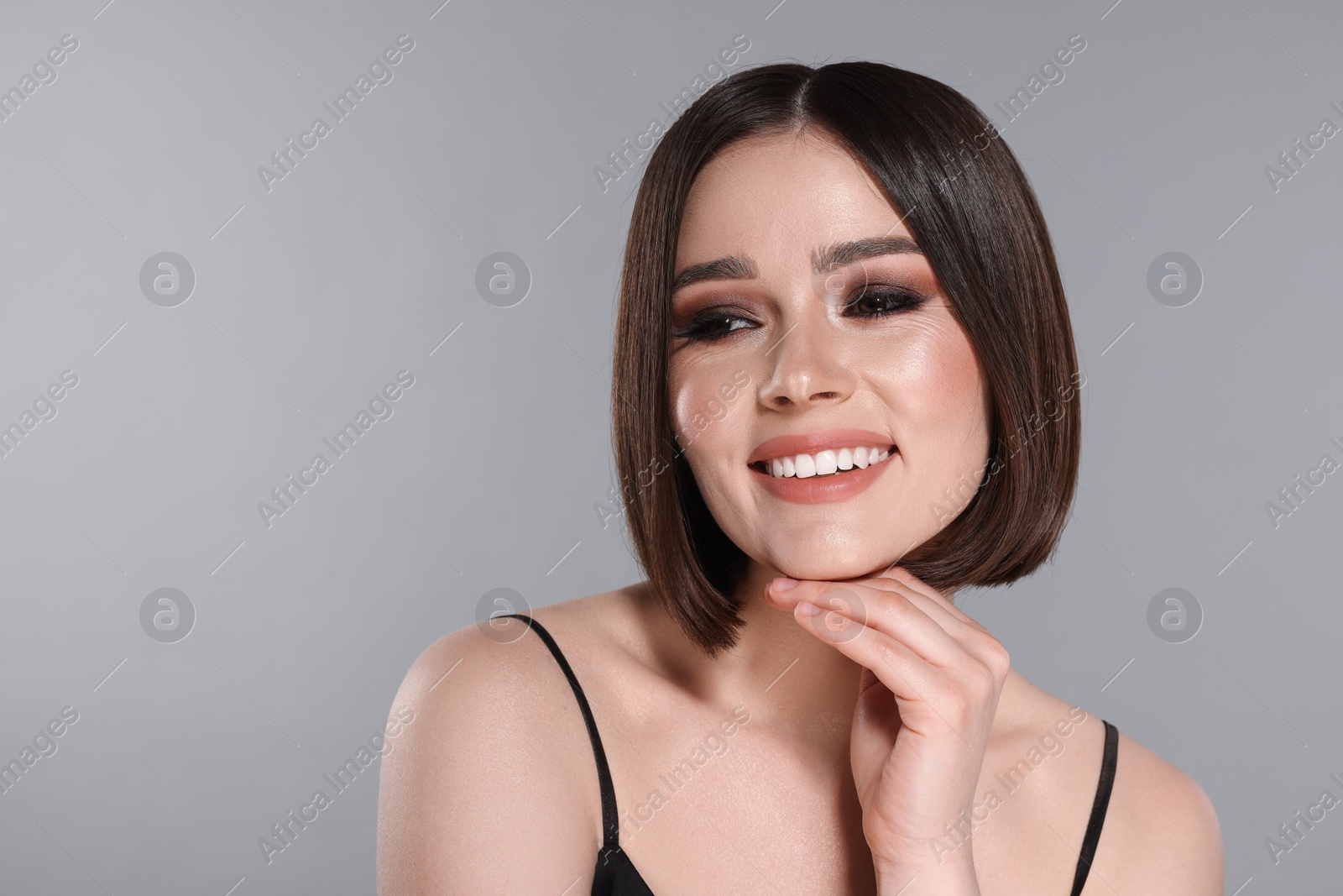 Photo of Portrait of beautiful young happy woman with gorgeous straight hair on light grey background, space for text