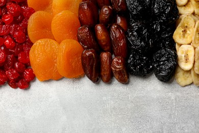 Photo of Different dried fruits on grey table, top view. Space for text