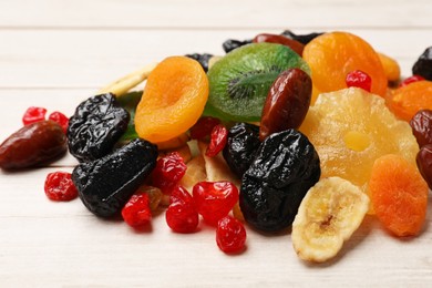 Photo of Mix of different dried fruits on wooden table, closeup