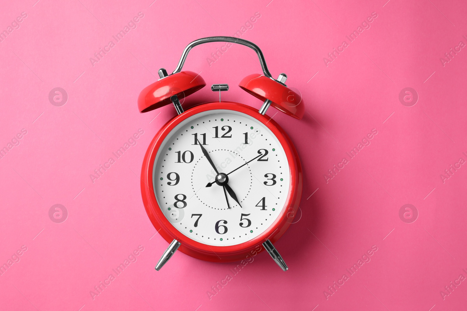 Red alarm clock on pink background, top view Photo of Red alarm clock on pink background, top view