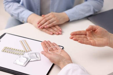 Photo of Contraception. Gynecologist recommending vaginal ring to woman in clinic, closeup