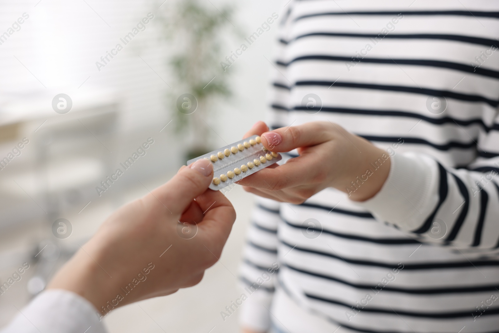 Photo of Gynecologist recommending contraceptive pills to woman in clinic, closeup