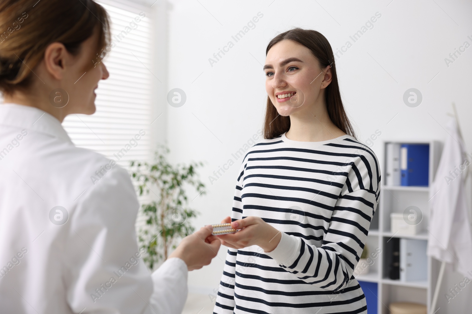 Photo of Gynecologist recommending contraceptive pills to woman in clinic