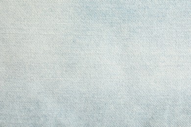 Photo of Texture of light blue jeans as background, closeup