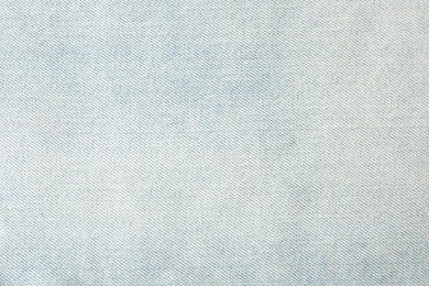 Photo of Texture of light blue jeans as background, closeup