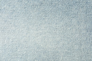 Photo of Texture of light blue jeans as background, closeup