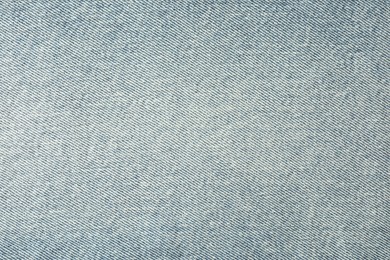 Photo of Texture of light blue jeans as background, closeup