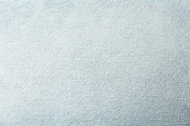 Photo of Texture of light blue jeans as background, closeup