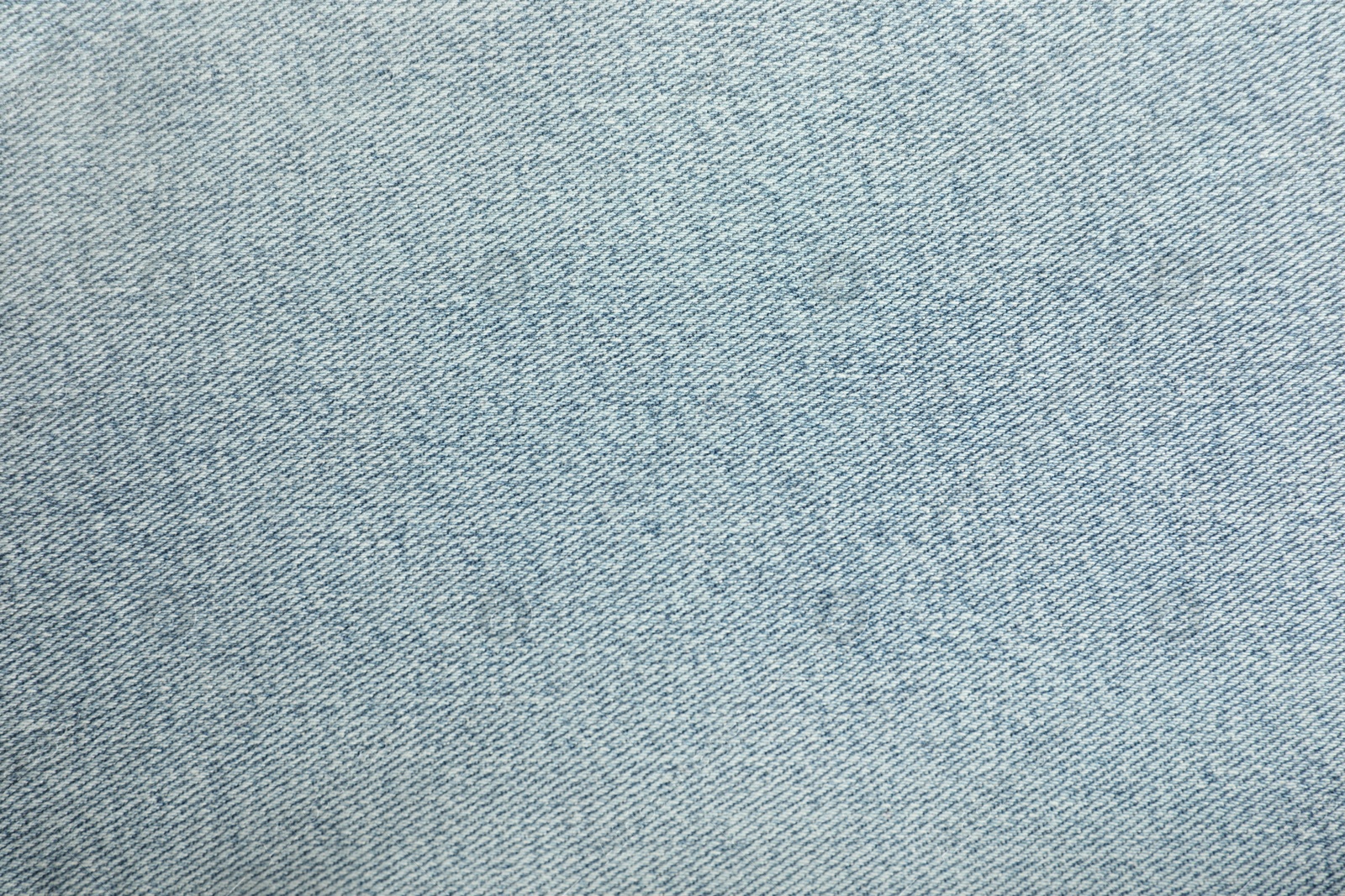 Photo of Texture of light blue jeans as background, closeup