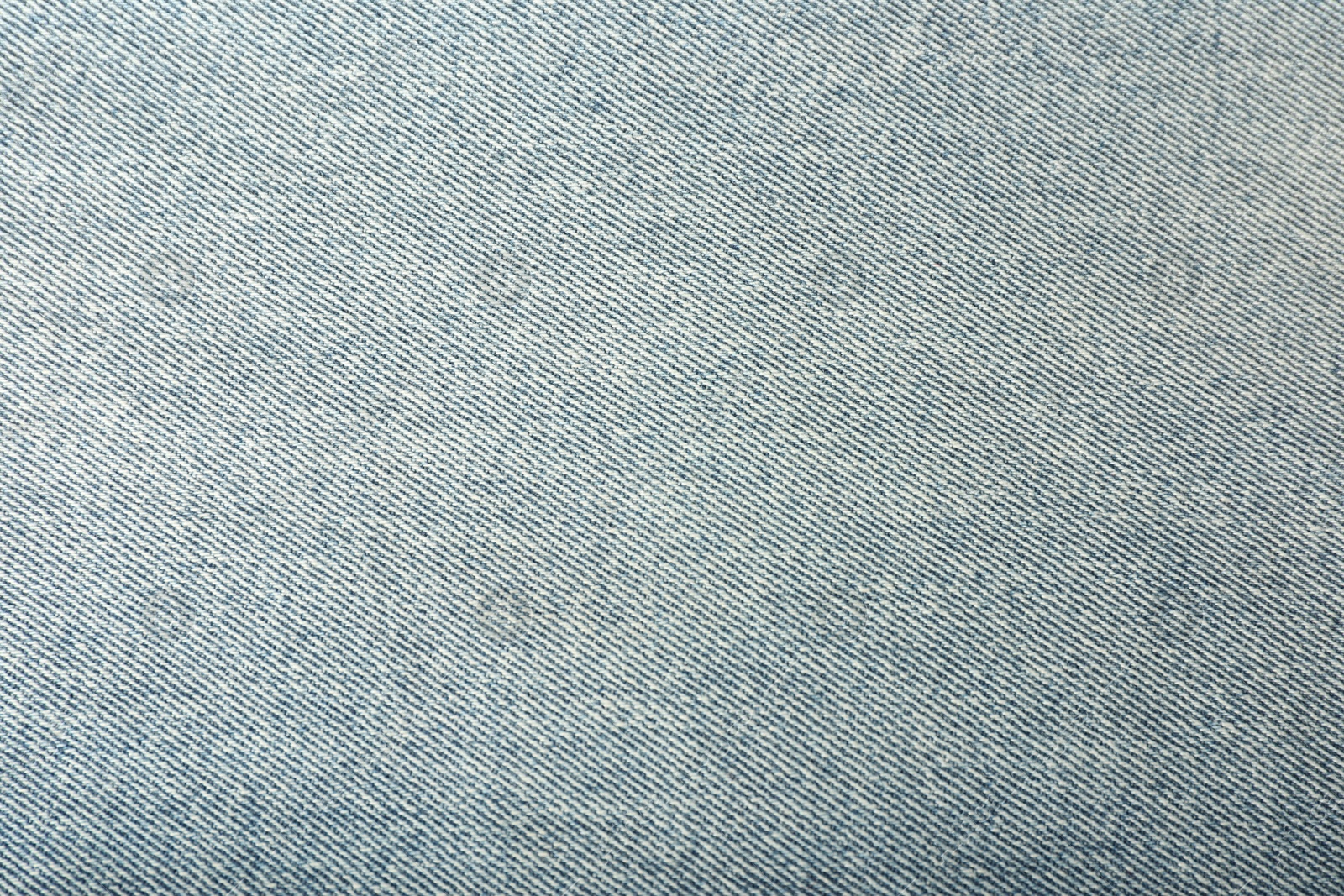 Photo of Texture of light blue jeans as background, closeup