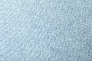 Photo of Texture of light blue jeans as background, closeup