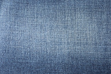 Photo of Texture of blue jeans as background, closeup