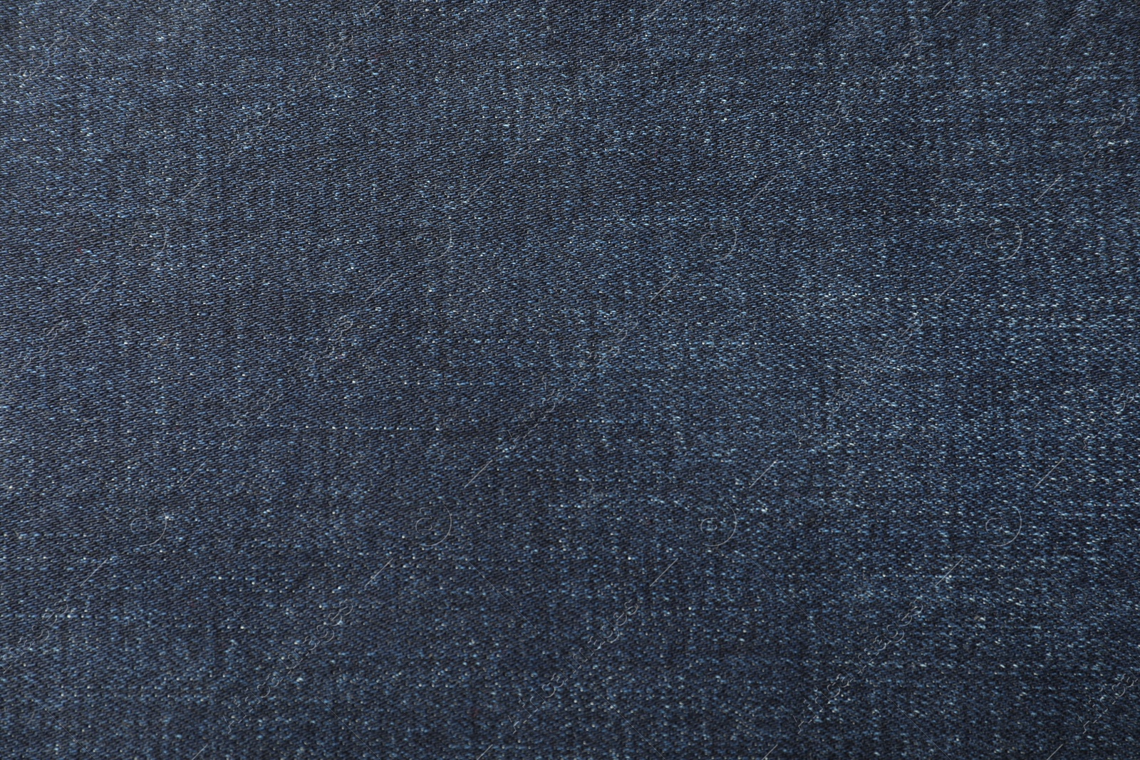 Photo of Texture of dark blue jeans as background, closeup