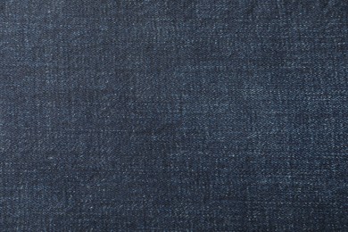 Photo of Texture of dark blue jeans as background, closeup