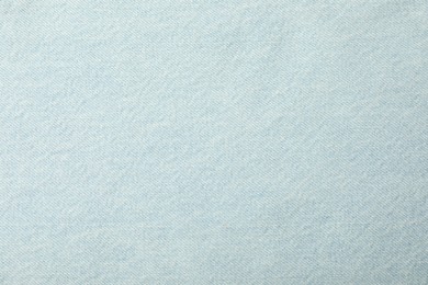 Photo of Texture of light blue jeans as background, closeup