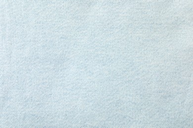 Photo of Texture of light blue jeans as background, closeup