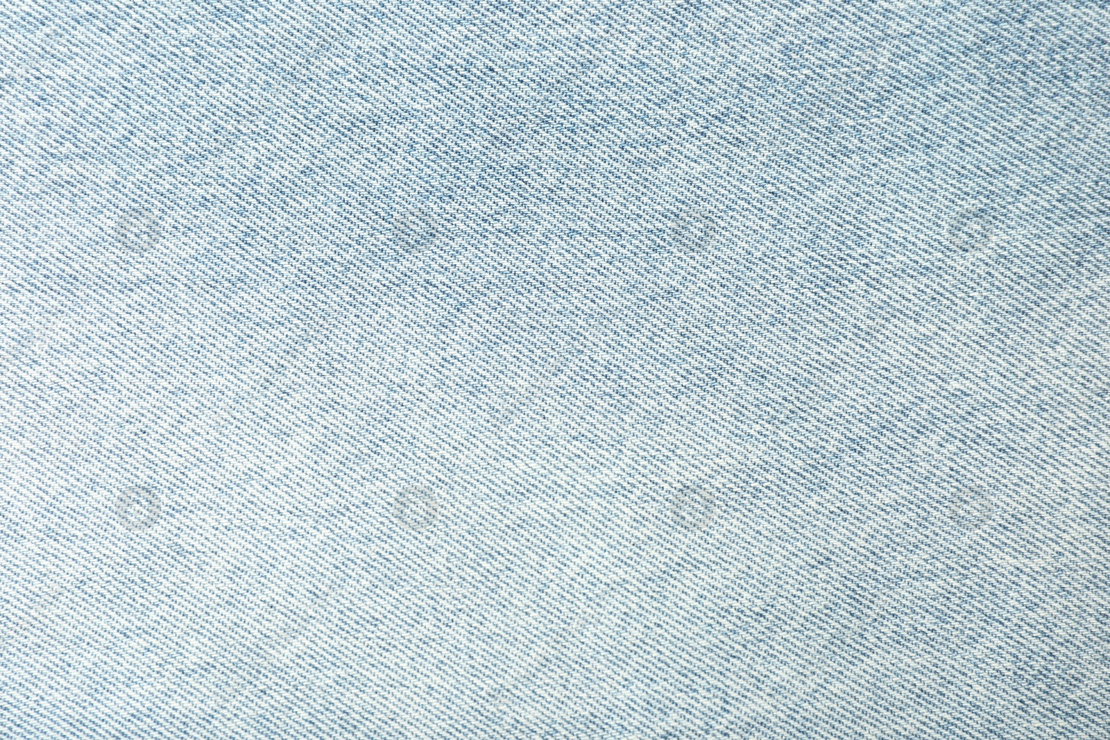 Photo of Texture of light blue jeans as background, closeup