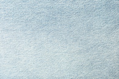 Photo of Texture of light blue jeans as background, closeup