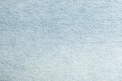 Photo of Texture of light blue jeans as background, closeup