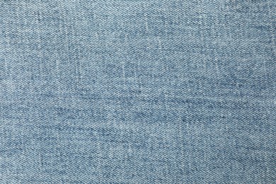 Photo of Texture of blue jeans as background, closeup