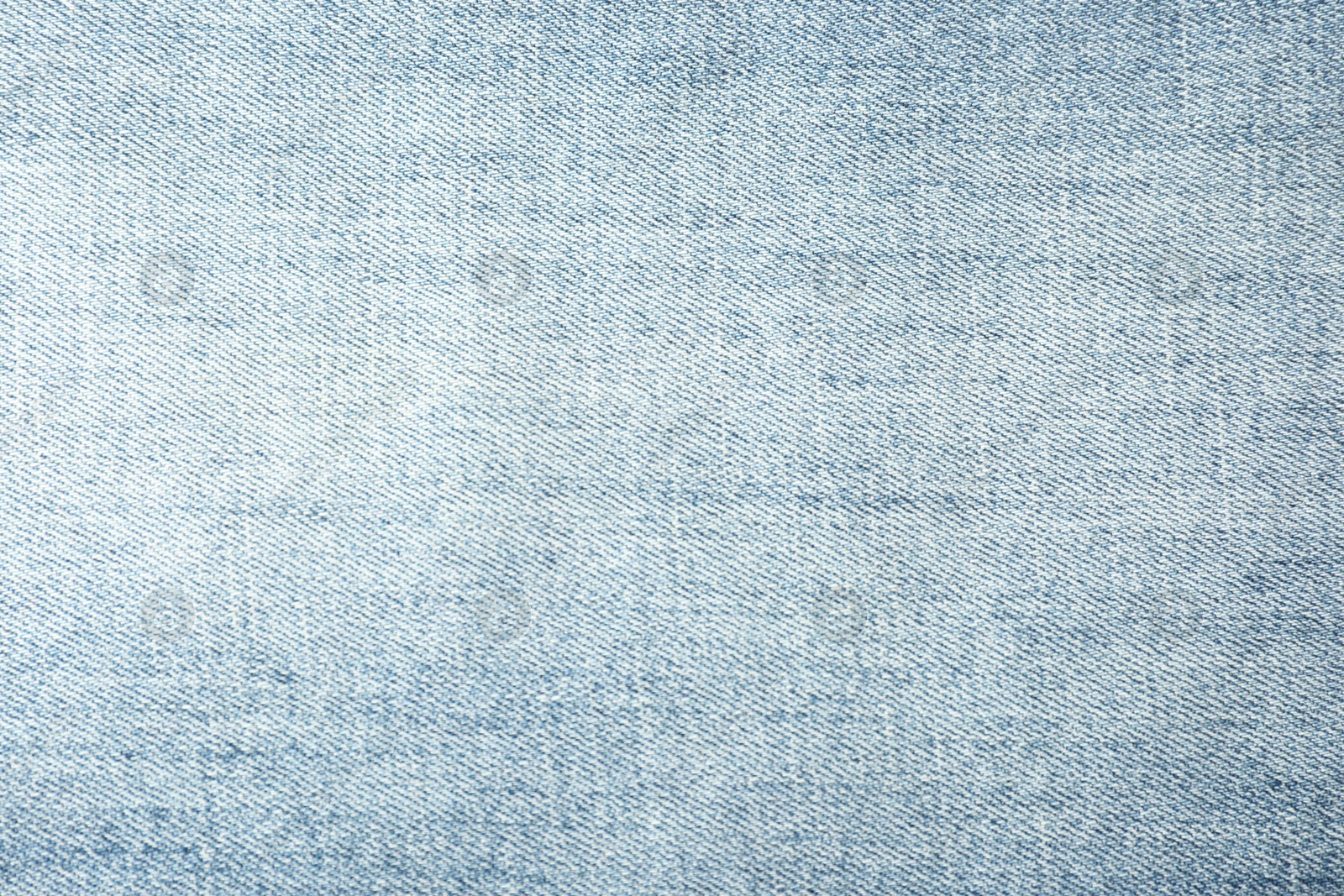 Photo of Texture of light blue jeans as background, closeup