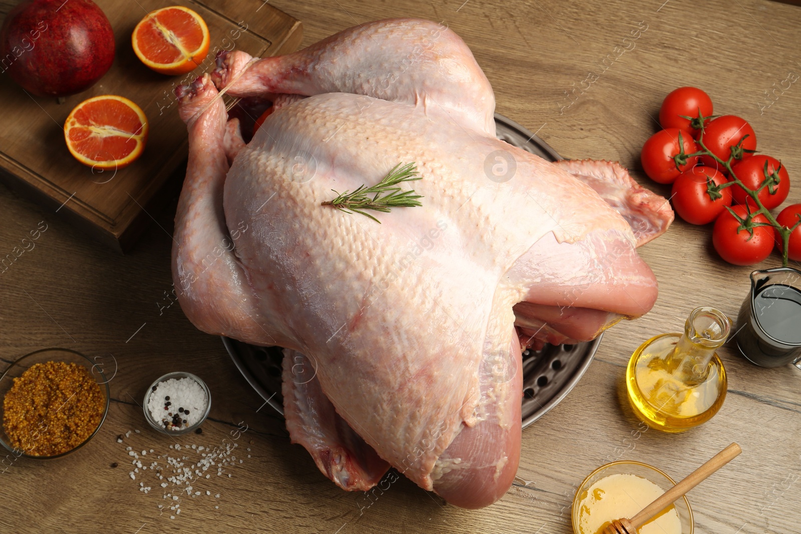 Photo of Whole raw turkey with ingredients on wooden table, flat lay