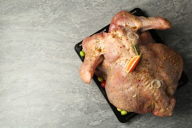 Photo of Whole raw turkey with marinade on grey table, top view. Space for text