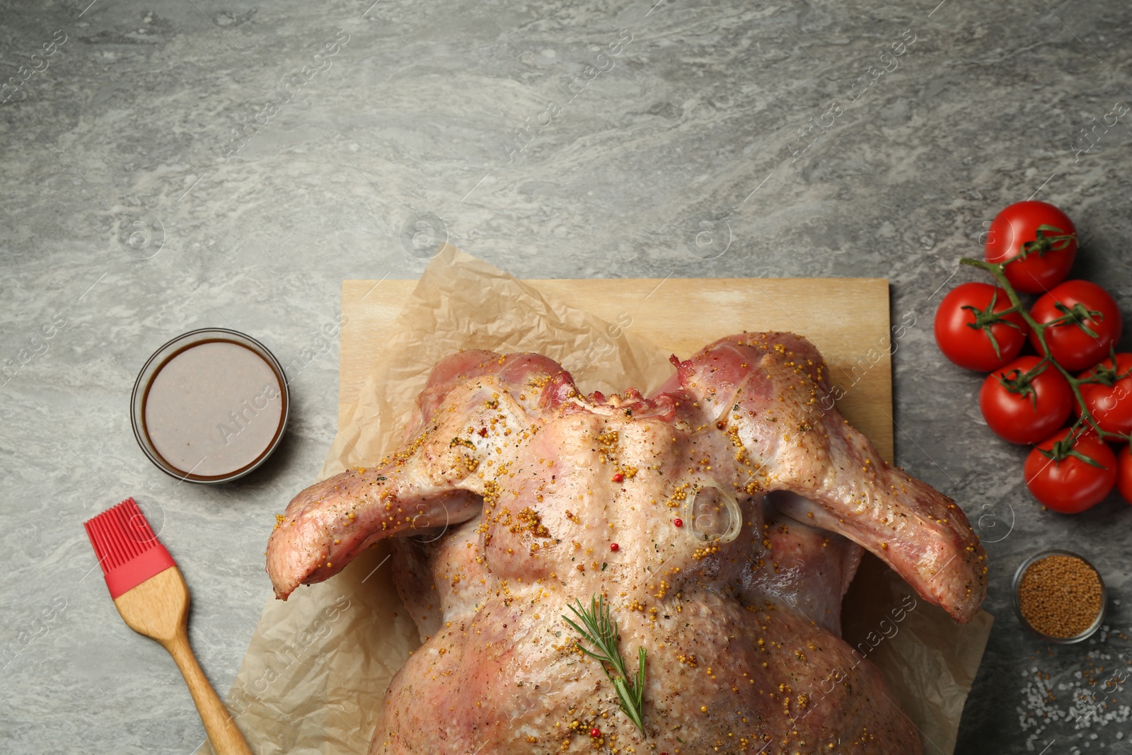 Photo of Whole raw turkey with ingredients for marinade on grey table, flat lay