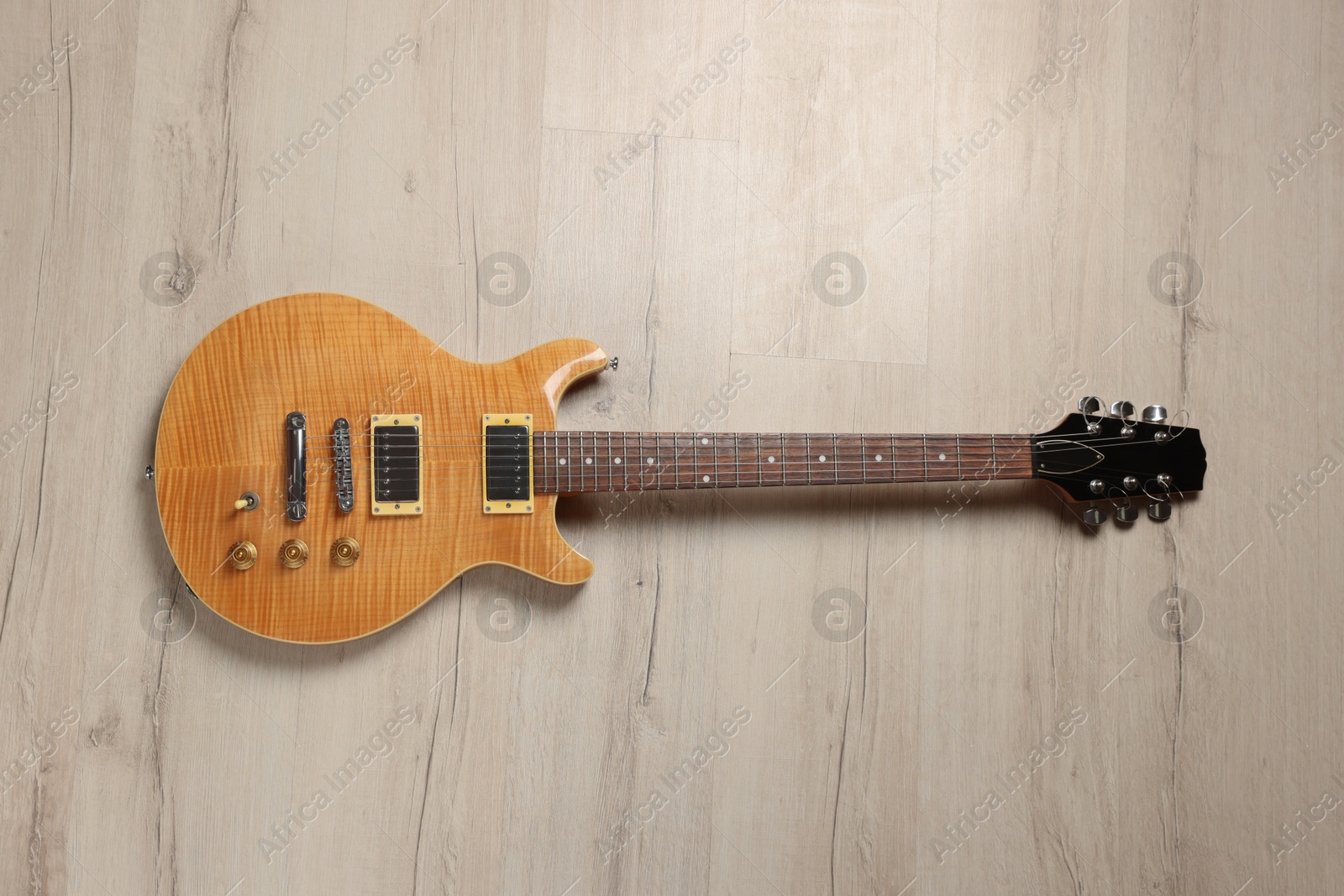 Photo of One modern electric guitar on wooden background, top view