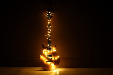 Photo of Electric guitar with Christmas lights on dark background